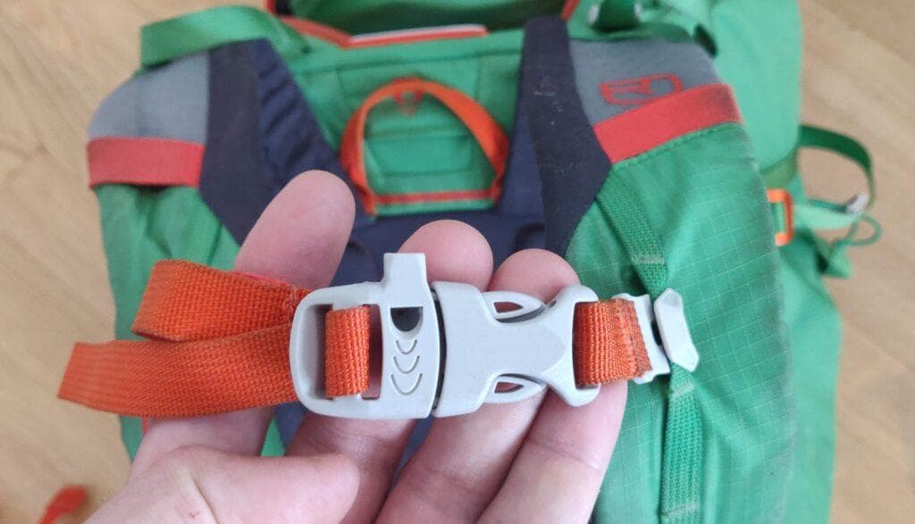 Backpack chest strap buckle serving as a whistle